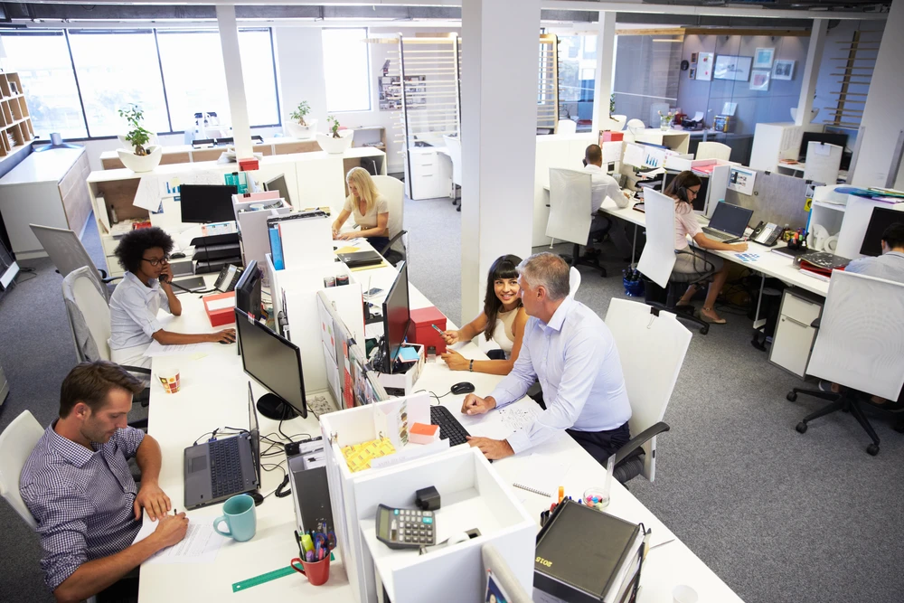 Bureau moderne en open space avec employés travaillant sur ordinateurs