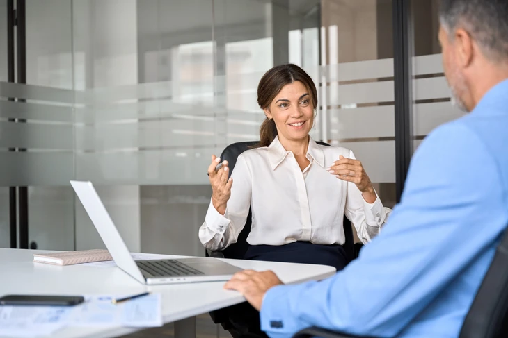 Réunion d'affaires dans bureau moderne avec cloisons vitrées