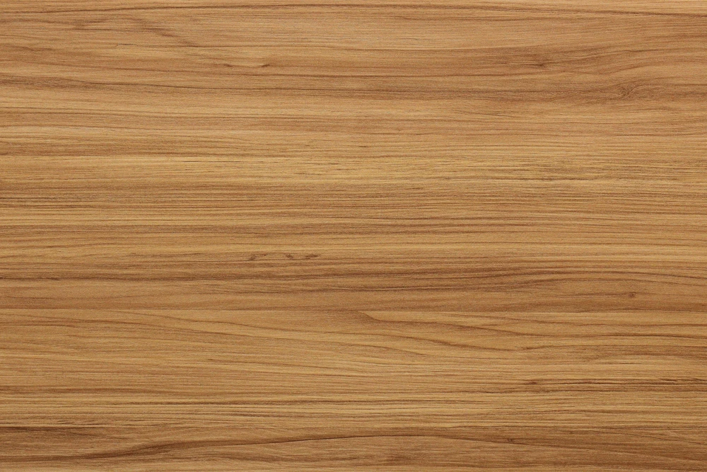 Surface de bois naturel aux tons chauds dorés et bruns, présentant un grain fin et régulier avec des veines horizontales caractéristiques