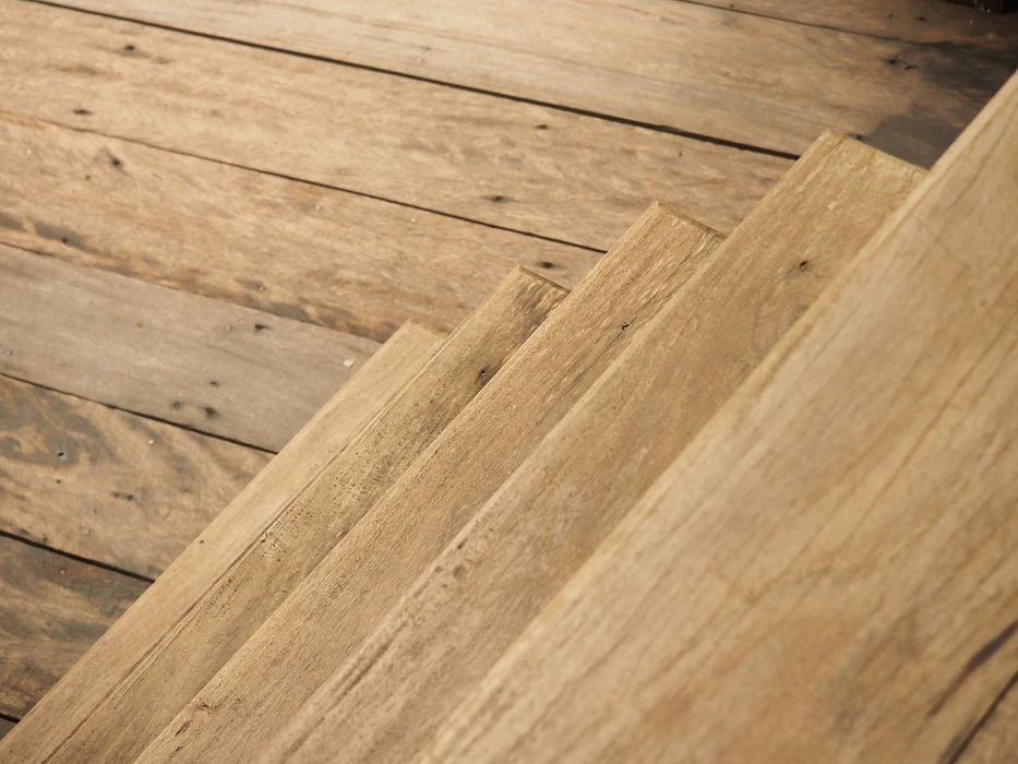 Atelier de menuiserie en intérieur avec planches de bois brut disposées sur établi