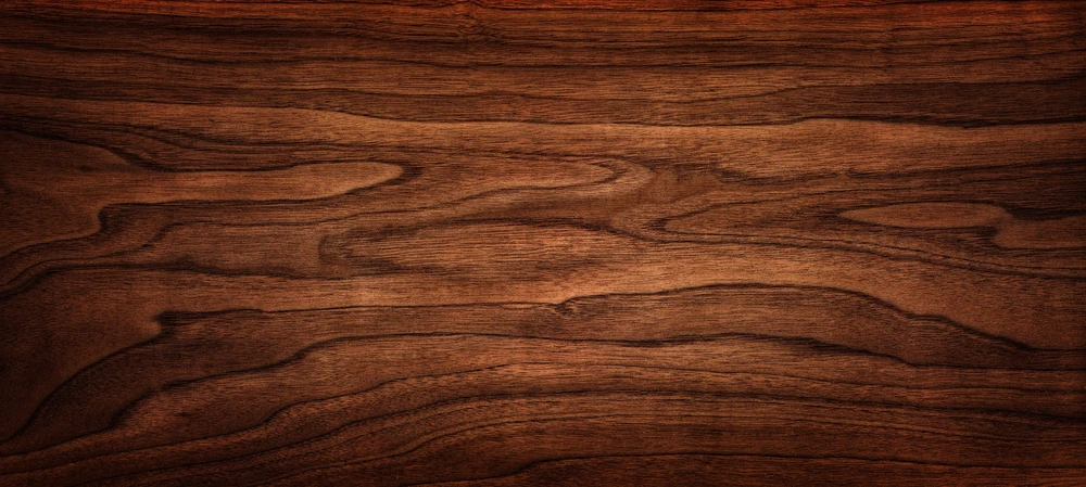 Surface en bois naturel présentant des veines ondulées caractéristiques, grain fin et régulier, finition satinée