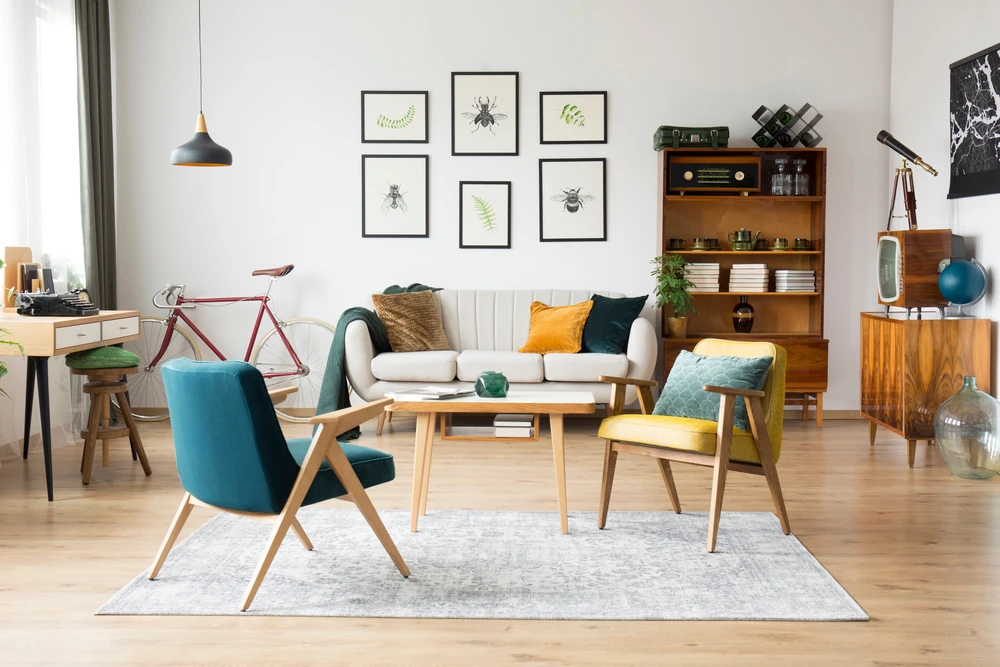 Mobilier élégant vintage dans un intérieur spacieux et plat avec canapé beige, chaises et affiches au mur
