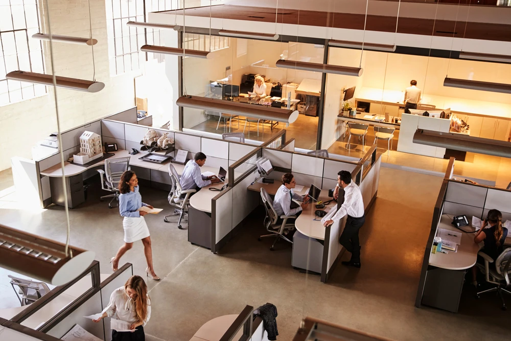 Espace de travail collaboratif moderne en open space avec employés en activité
