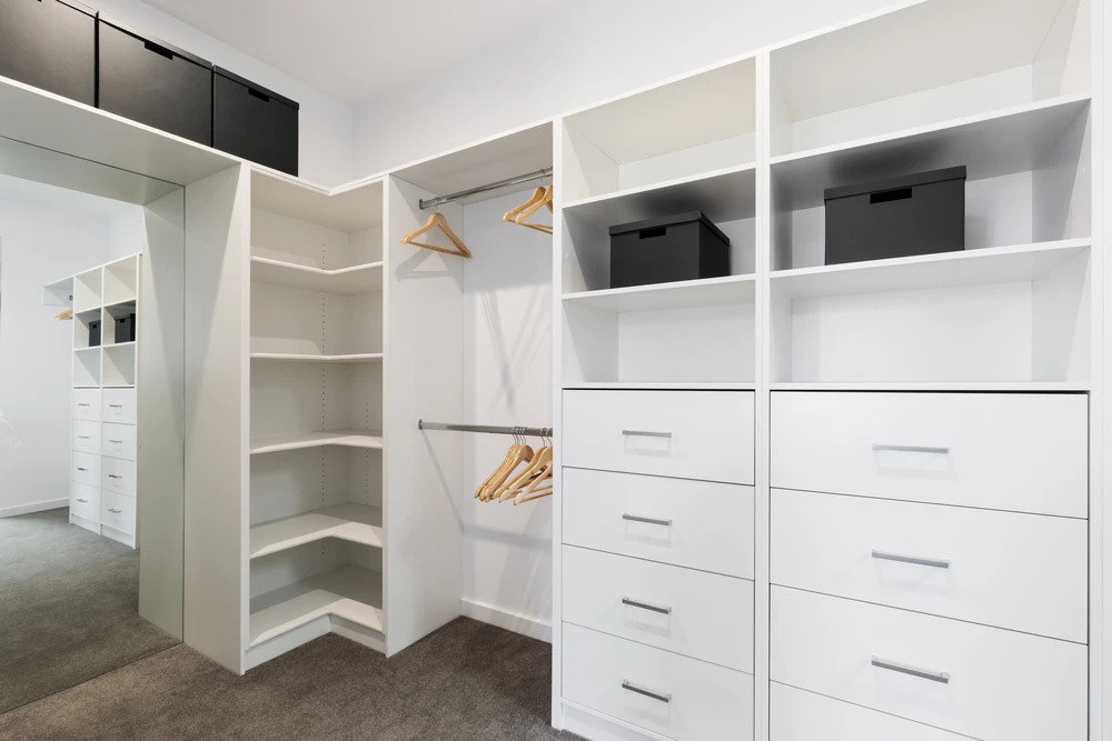 Dressing moderne sur mesure avec aménagement optimisé comprenant penderies doubles niveaux, étagères d'angle, tiroirs multiples et rangements compartimentés