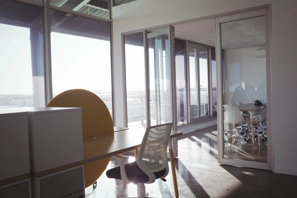 Bureau moderne avec mobilier contemporain, chaises ergonomiques et cloisons vitrées