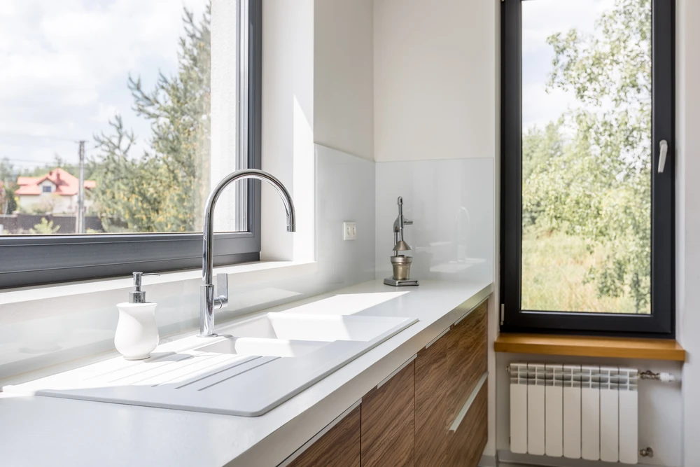 Cuisine moderne avec plan de travail en marbre blanc veiné, évier intégré et robinet mitigeur chromé au design contemporain