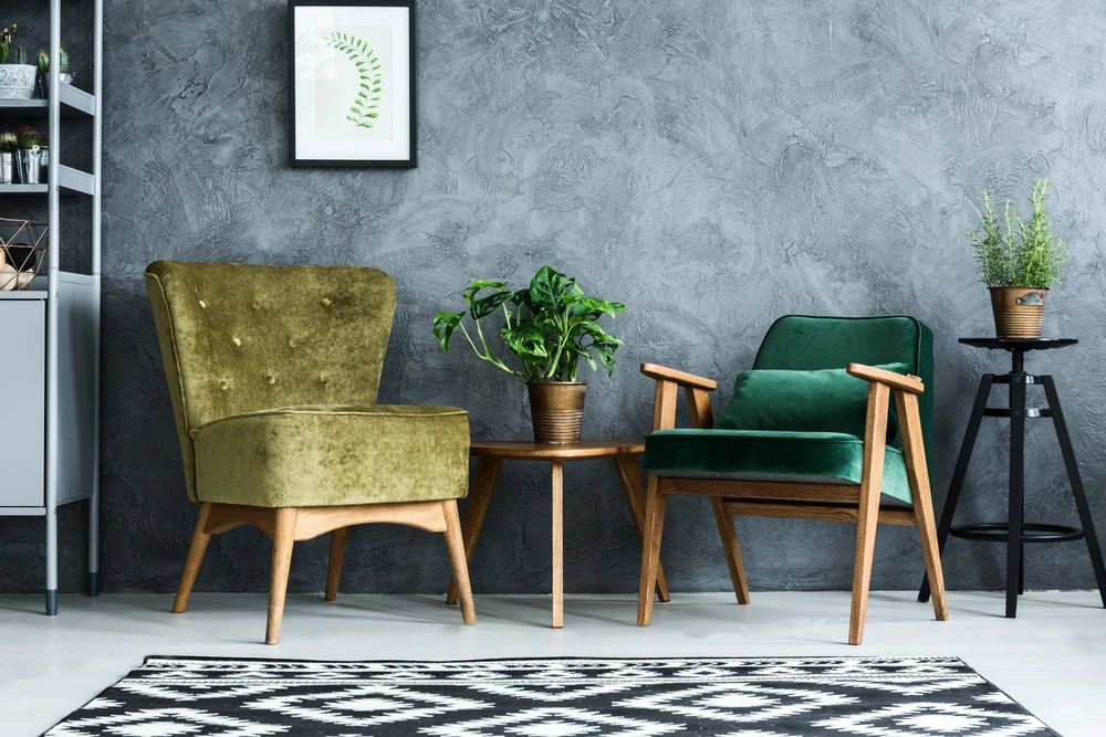 Intérieur moderne avec deux fauteuils en velours vert olive et émeraude, piètement bois naturel