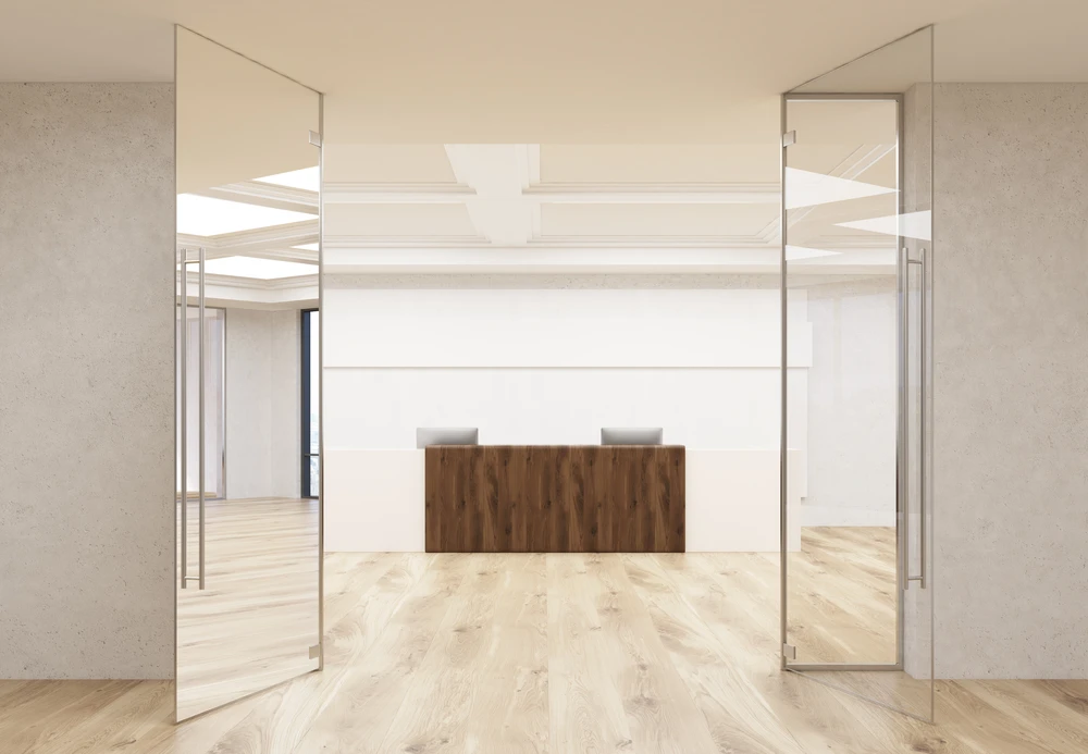 Espace de réception d'entreprise moderne avec comptoir d'accueil en bois et fauteuils gris