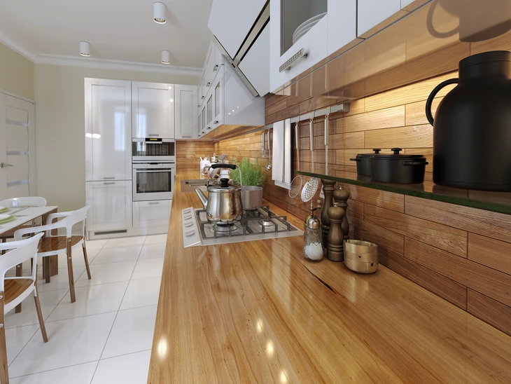 Cuisine moderne avec îlot central en bois massif, plan de travail intégrant plaque de cuisson gaz