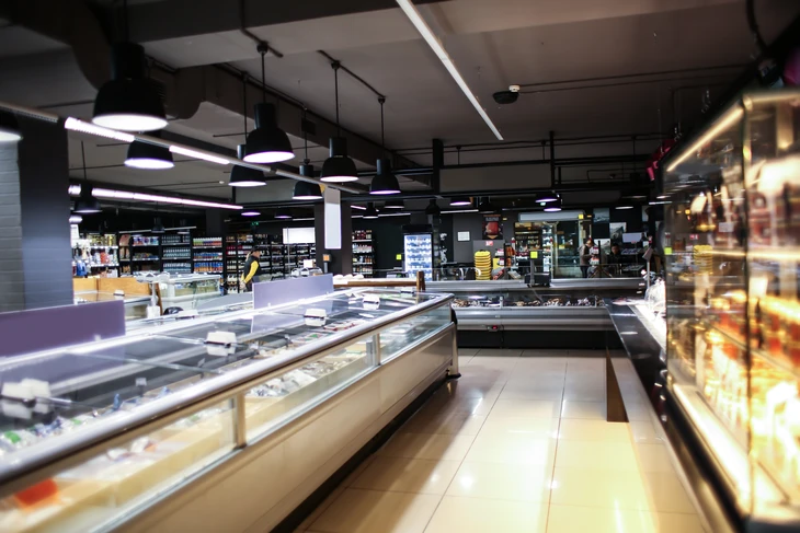 Intérieur de magasin alimentaire moderne avec comptoirs réfrigérés en îlot central et vitrines murales