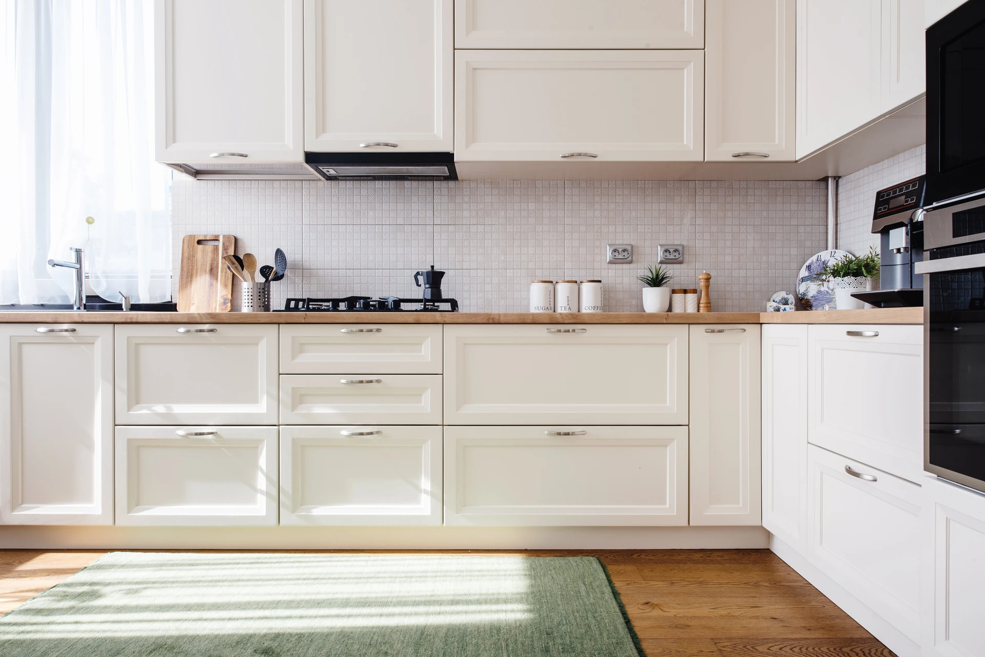 Cuisine moderne avec façade de meubles blancs style traditionnel, plan de travail en bois massif, crédence carrelage blanc petit format