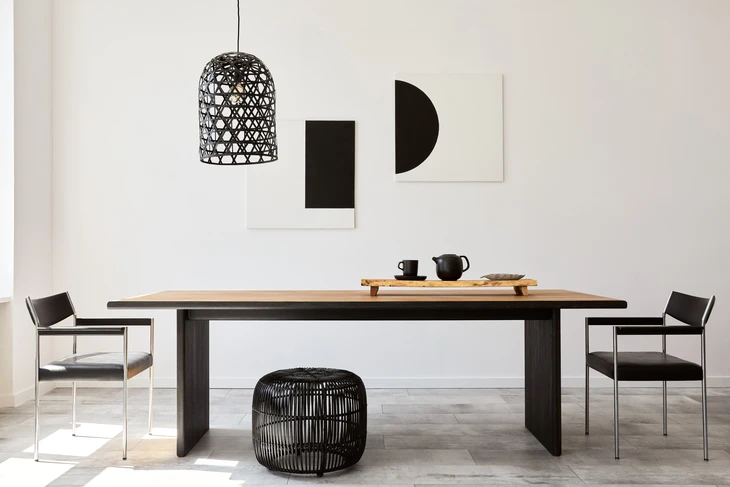Salle à manger moderne minimaliste avec table en bois massif à piètement métallique noir, chaises contemporaines à structure chromée et assise noire