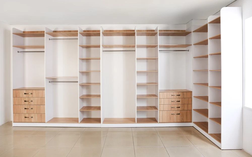 Dressing spacieux avec aménagement sur mesure comprenant penderies, étagères et tiroirs intégrés
