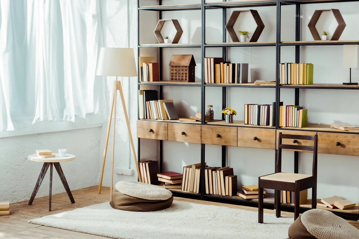 Intérieur moderne avec bibliothèque modulaire en métal noir et bois, remplie de livres colorés
