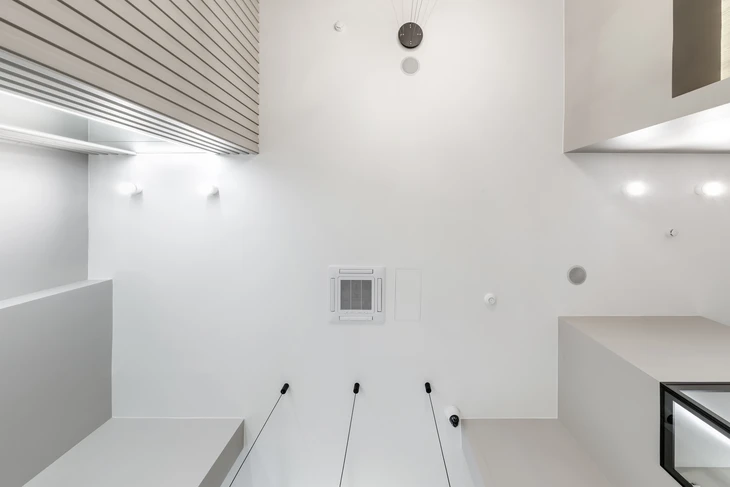 Salle de conférence moderne avec plafond acoustique à lames métalliques, éclairage LED encastré et système de climatisation cassette intégré
