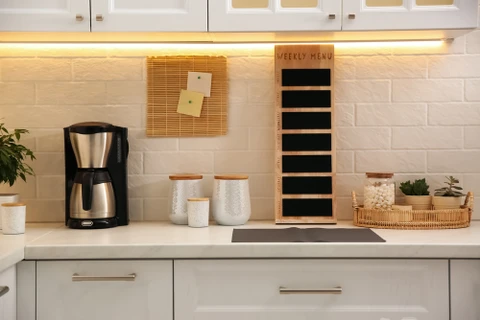 Cuisine moderne avec plan de travail blanc, crédence carrelage métro blanc, éclairage LED sous meuble